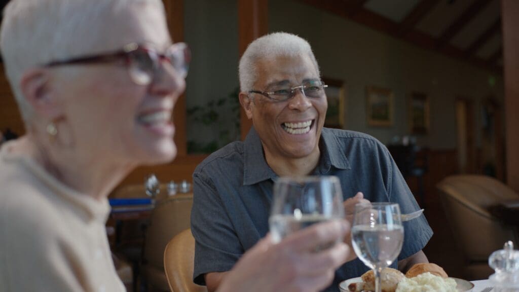 - Grace Management Joyful residents enjoying a shared meal at Snow Canyon Retirement Community, highlighting the social atmosphere of independent living near St. George.