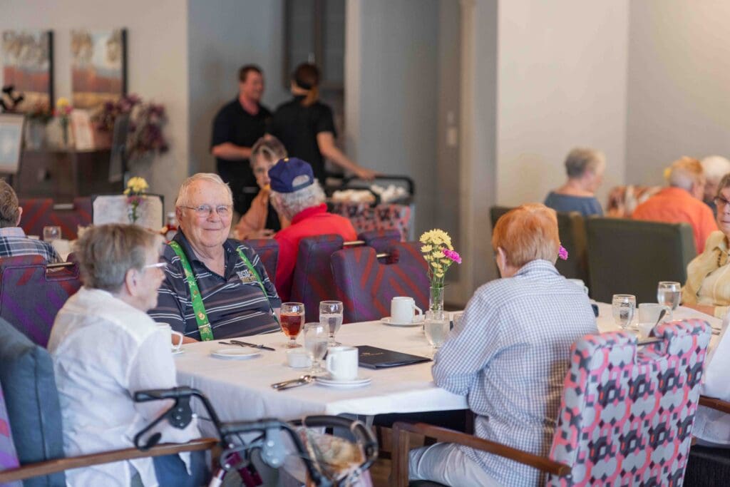 - Grace Management Residents sharing a meal in the dining room at The Pointe at Meridian, a welcoming community for independent living.