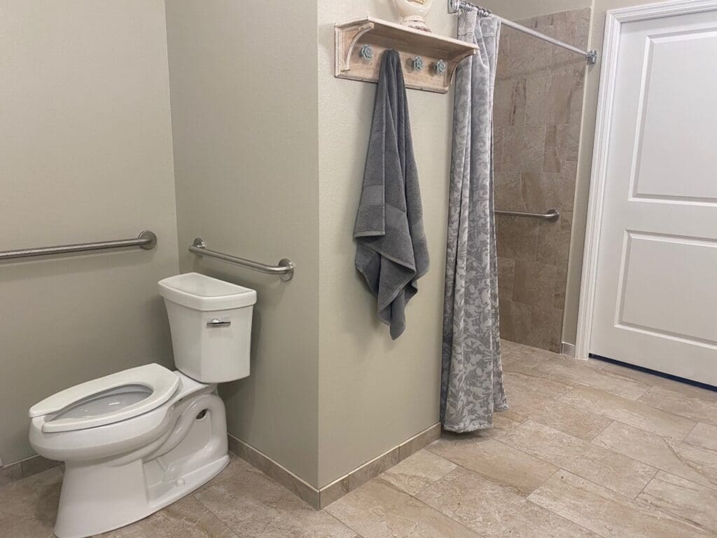 - Grace Management Resident's private bathroom at Palm Bay Memory Care, a community offering senior living.
