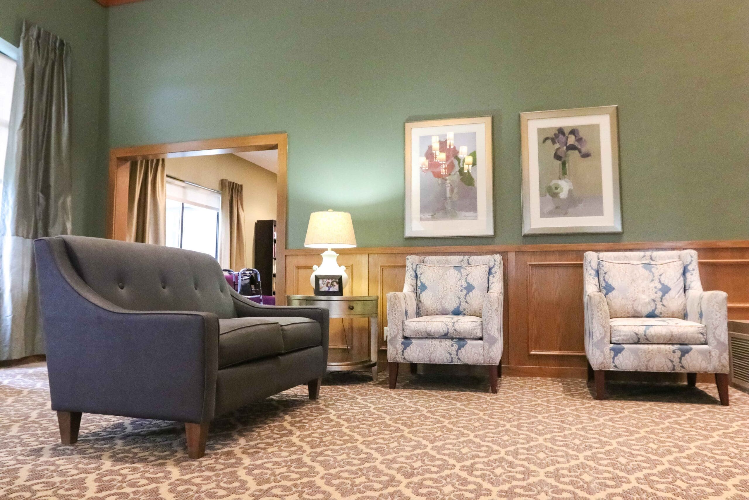 - Grace Management Interior image of a sitting room with artwork, tall ceilings, and comfortable chairs at Sedgwick Plaza.