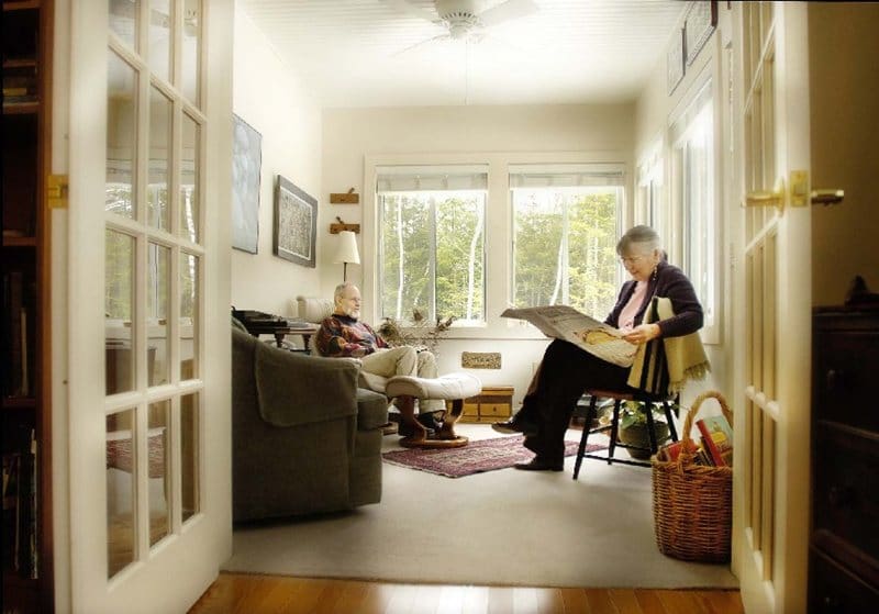 - Grace Management Residents sit in their living room / sitting room reading the newspaper with views of the forest outside their windows at Dirigo Pines senior living near Bangor, ME.