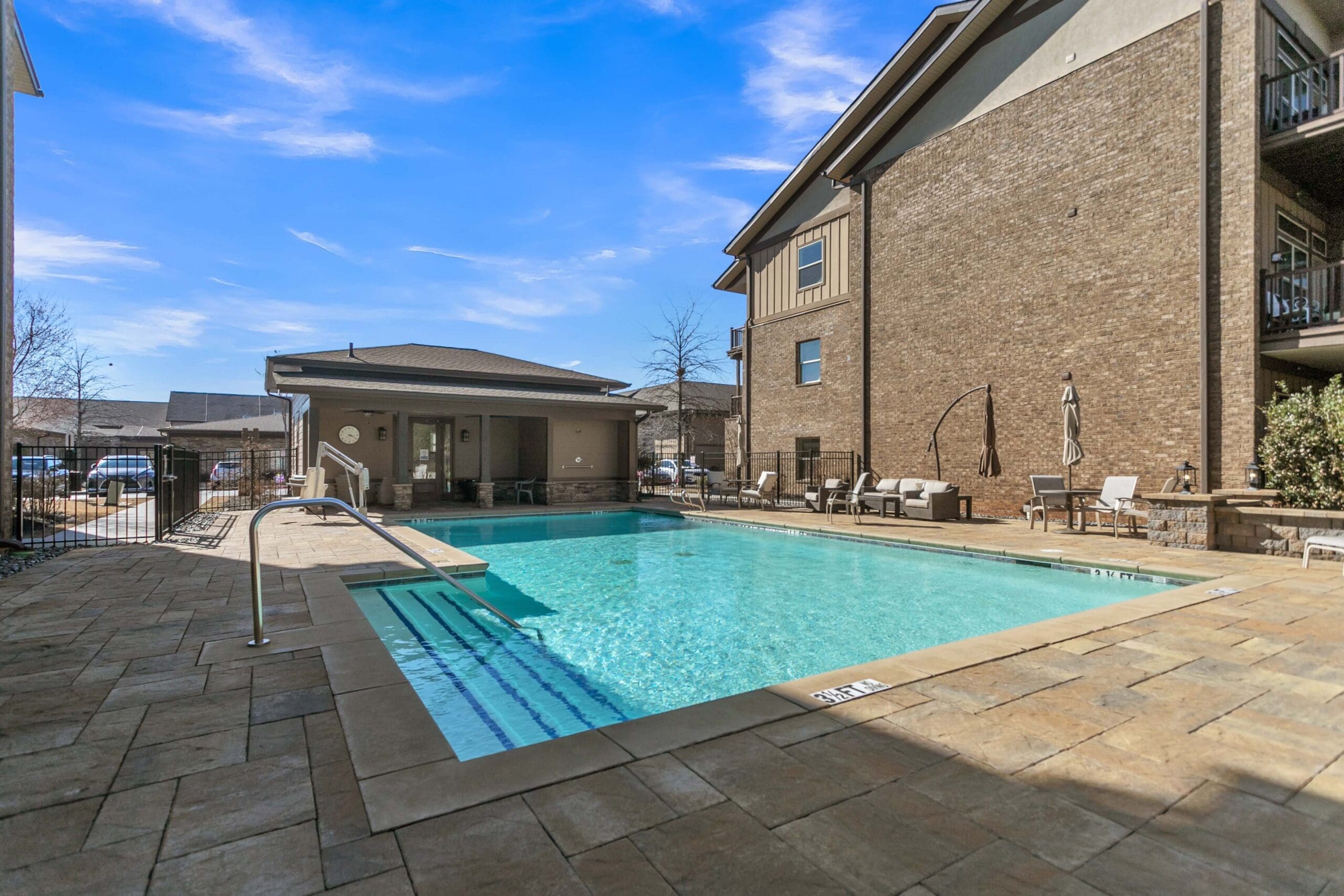 - Grace Management An outdoor pool with poolside tables and chairs at Celebration Village Forsyth, a senior living community near Cumming, GA.