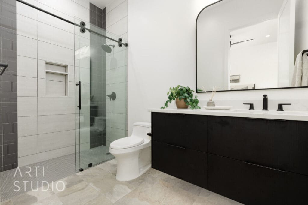 Modern bathroom featuring a sleek glass shower, stylish black cabinetry, and elegant decor with plants for a serene ambiance.
