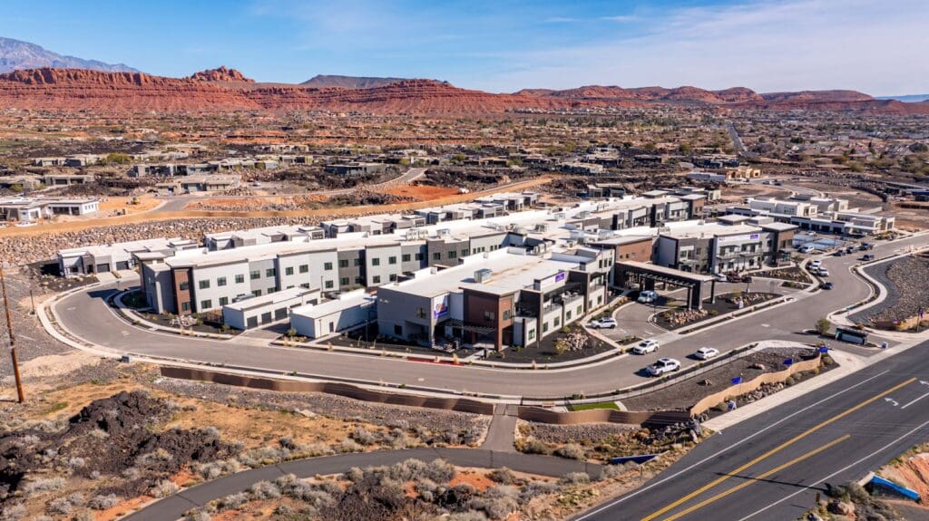 Aerial view of a modern senior living community surrounded by vibrant red rock formations and scenic landscapes.