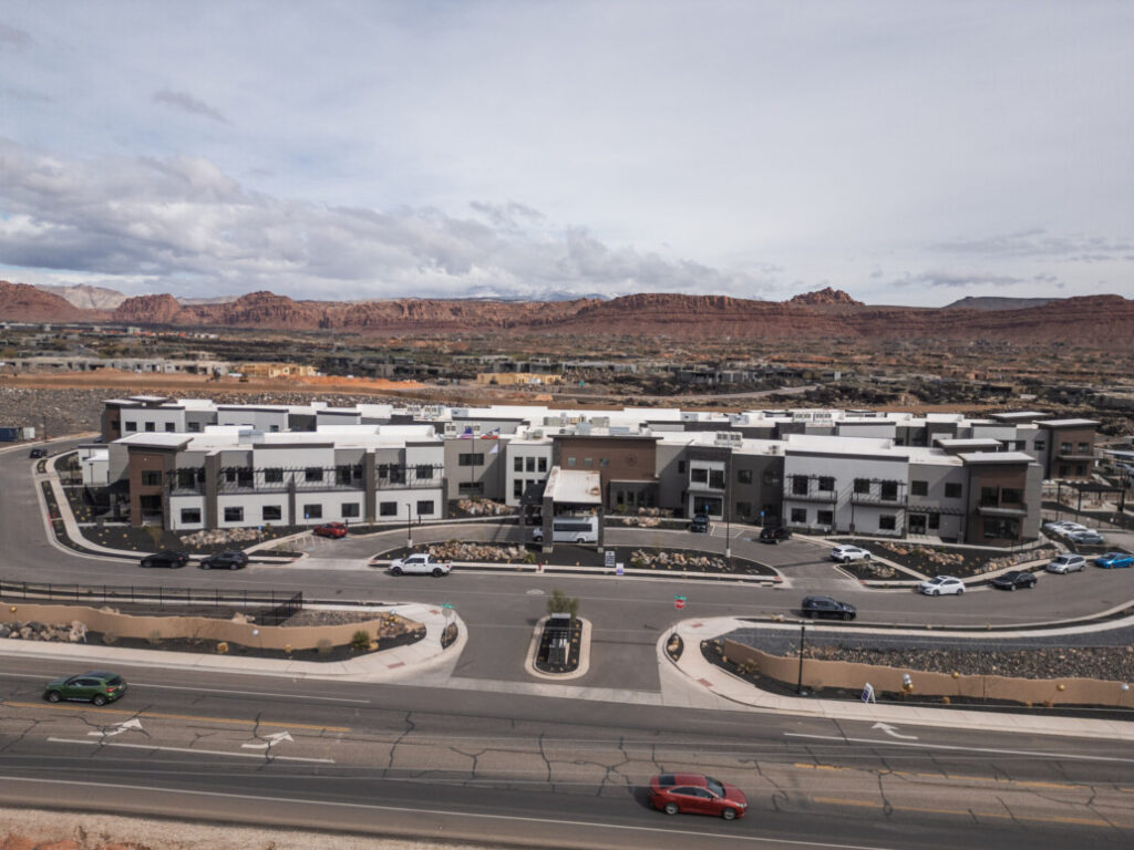 Modern senior living community with upscale amenities, surrounded by stunning natural landscapes and scenic mountains.