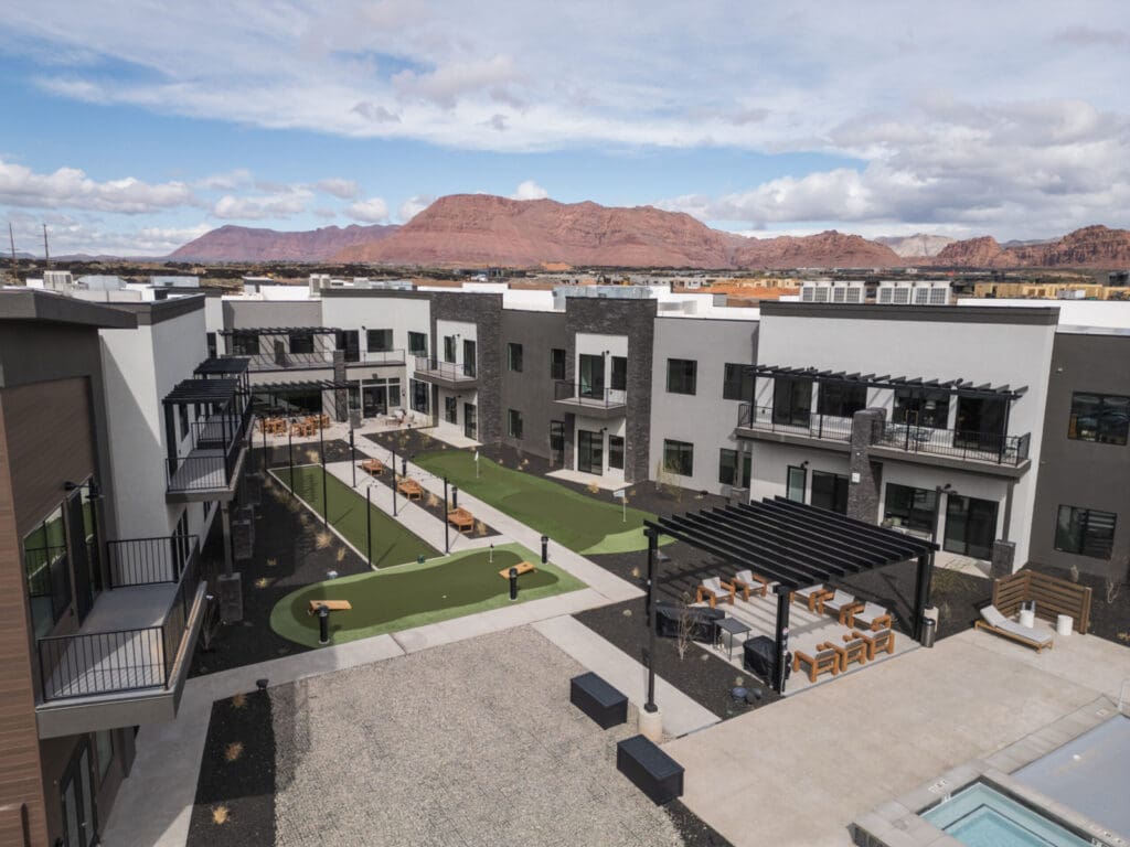 Modern senior living courtyard featuring upscale amenities, vibrant seating areas, and stunning mountain views.