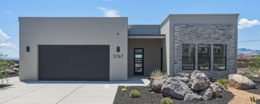 Stylish modern home exterior featuring a sleek garage, attractive landscaping, and vibrant architectural details.