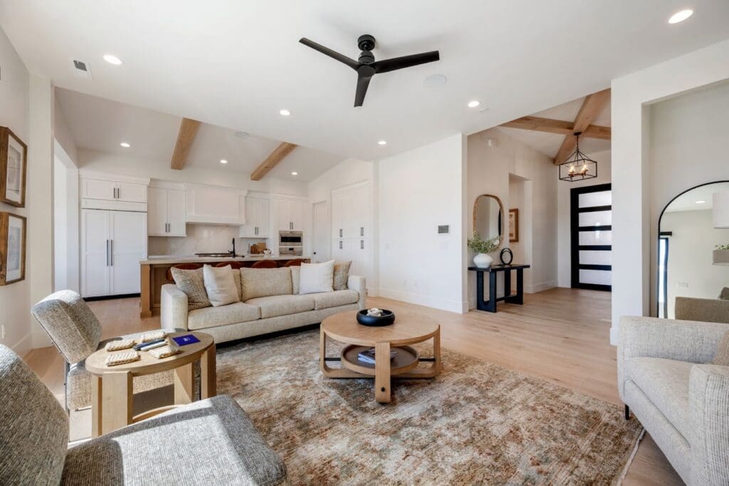 Stylish living space featuring a cozy sofa, elegant decor, and modern kitchen, enhancing a vibrant lifestyle in senior living.