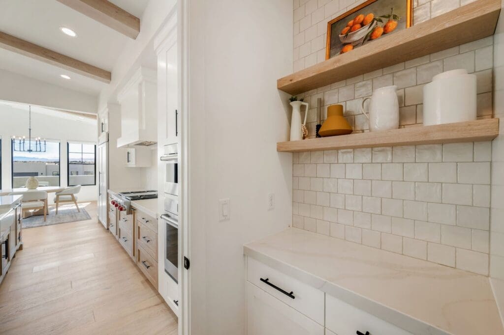Bright, airy kitchen with stylish cabinetry, elegant decor, and views of a dining area, showcasing a vibrant living space.