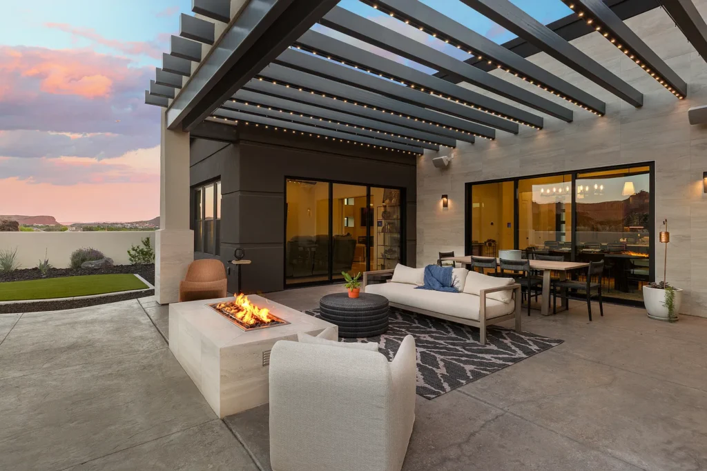 Stylish outdoor seating area with fire pit, dining table, and mountain views under a painted sky, perfect for vibrant gatherings.