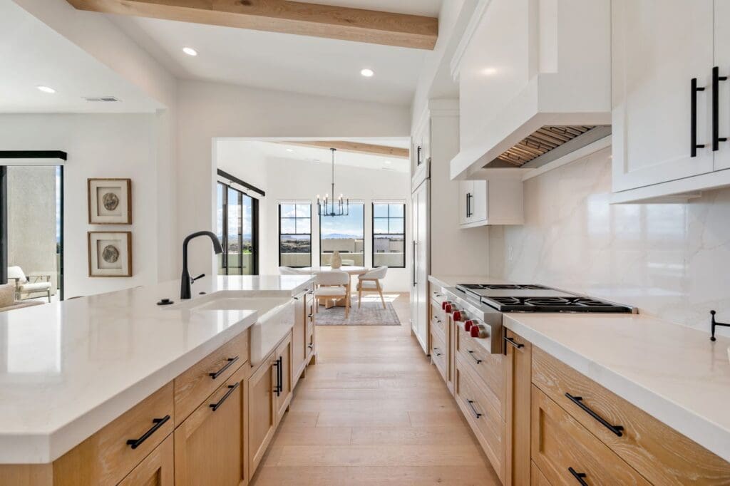 Modern kitchen with elegant cabinetry, sleek countertops, and a spacious dining area with large windows showcasing a vibrant view.