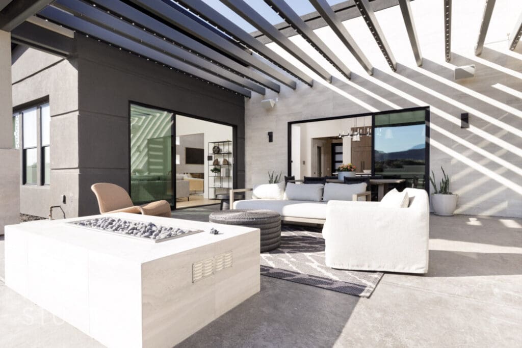 Outdoor living space featuring comfortable seating, a fire pit, and modern design elements with a view of the surroundings.