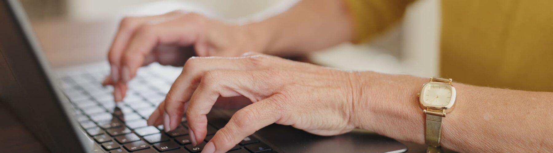 Hands typing on a laptop.