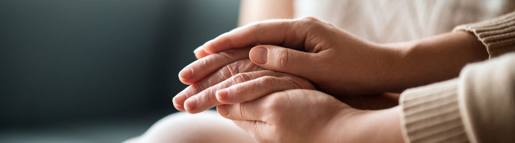 A warm exchange of care as two hands gently clasp together, symbolizing compassion and connection in a serene setting.