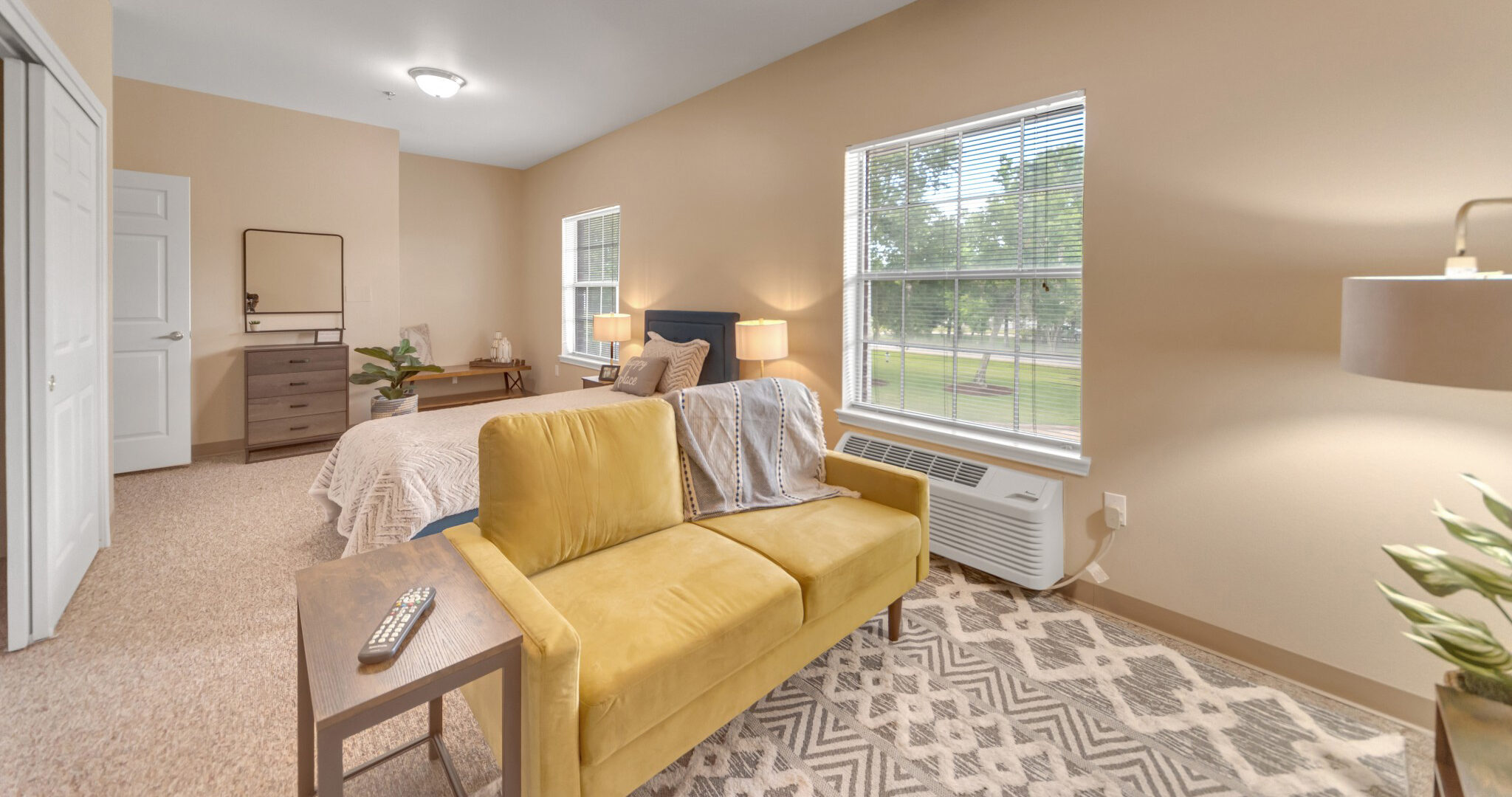 DSC_5171-1-e1688566732443 - Grace Management Interior shot of Collier Park, showing a studio apartment with a combined, spacious living room and bedroom. The windows let in lots of natural light.