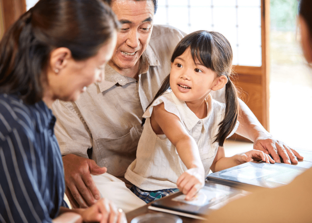 Multi-generational family joyfully engaging around a table, sharing moments and treasures in a warm, welcoming setting.