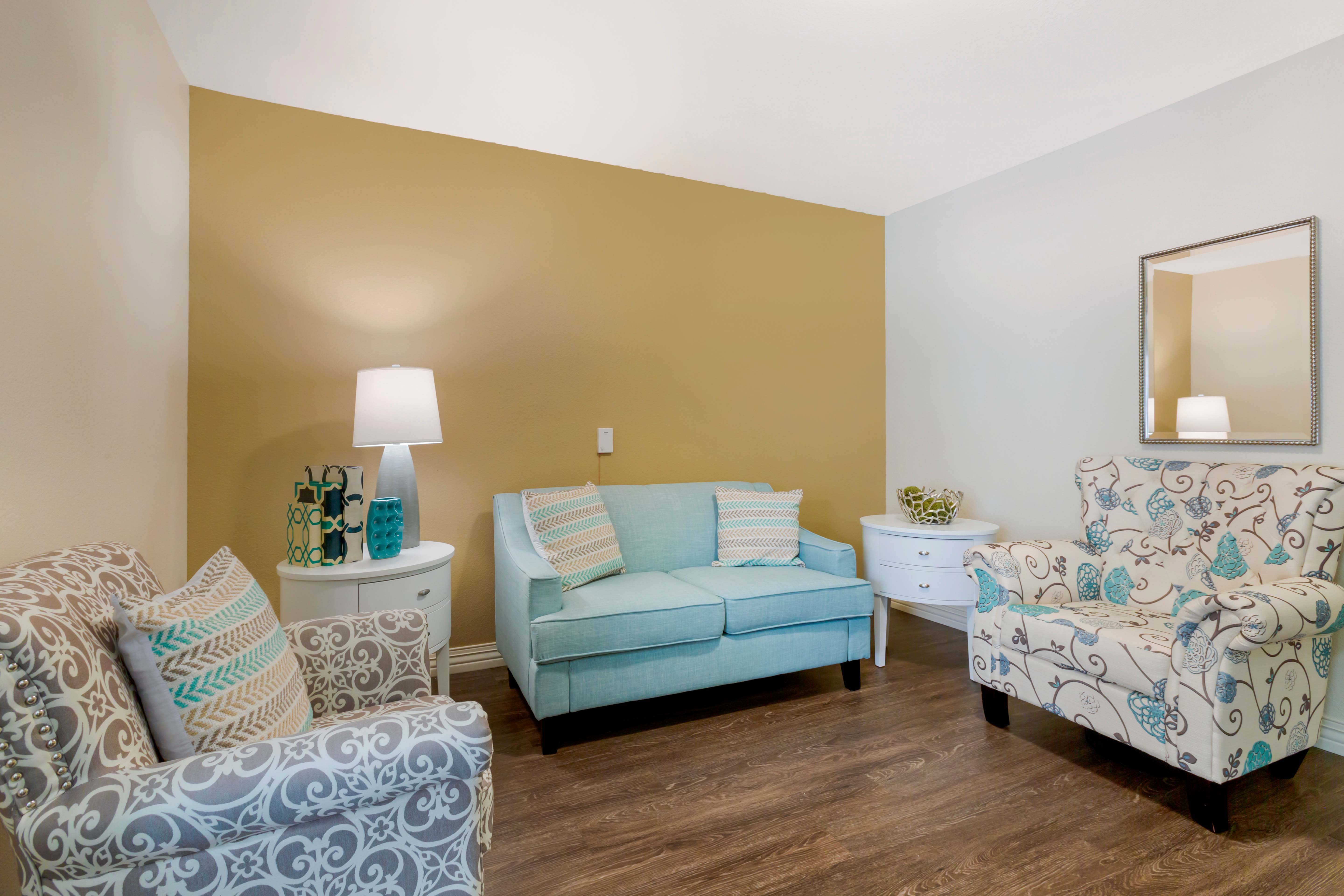 inspirations-of-peoria-north-phoenix-303A2198 - Grace Management Resident's living room with comfortable furniture and warm paint colors at Inspirations of Peoria senior living.