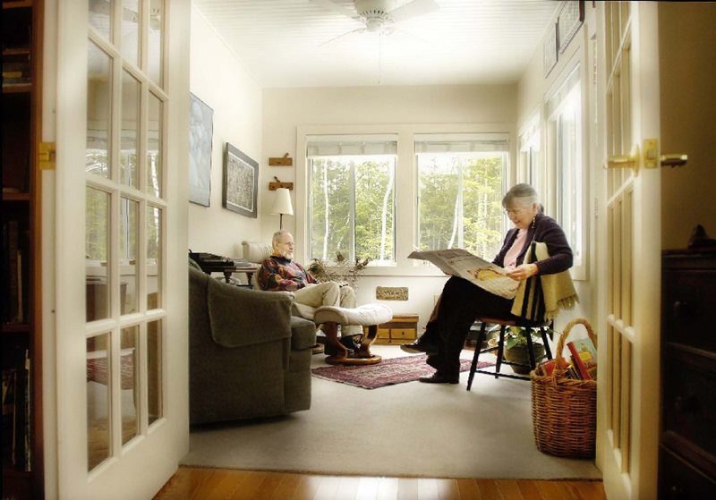 Resident sits in their living room / sitting room reading the newspaper at Dirigo Pines senior living near Bangor, ME.