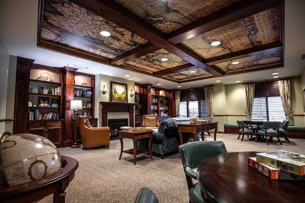 5H8A1828-1024x683 - Grace Management Interior image of a common area with leather chairs, wood panelling, and welcoming atmosphere at The Summit of Coralville.
