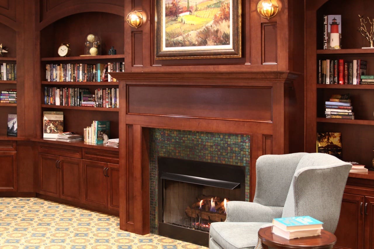IMG_3582-Large - Grace Management Interior image of The Summit of Citrus Hills sitting room/library with a warm fireplace and wood panelling.