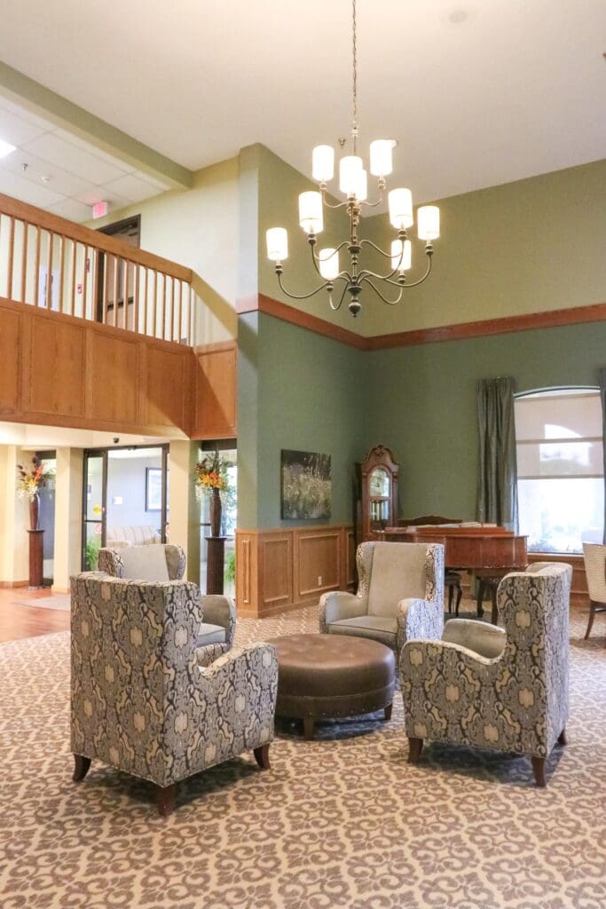 IMG_9831-683x1024 - Grace Management Common area at Inspirations of Bartlesville with vaulted ceilings, chandelier, and comfortable seating.
